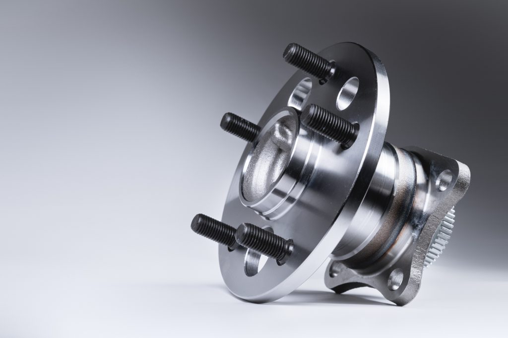 new wheel hub assembly with bearing this is part of the car suspension on a gray background with a gradient the concept of new car parts bearings for trailer wheels